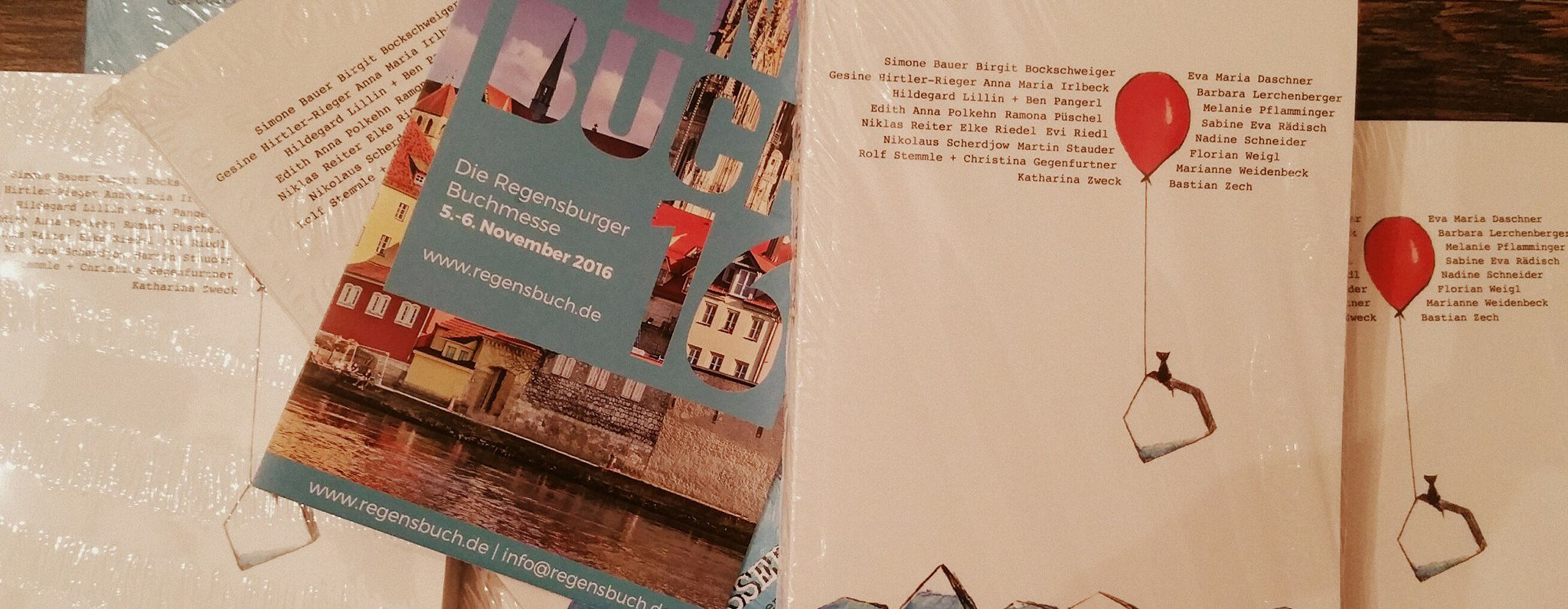 Unsere ehemalige Praktikantin Hilda berichtet: Pressearbeit – begleitet mich auf dem beruflichen Weg und im Ehrenamt Buch Wassergeflüster und Flyer der Regensburger Buchmesse zu sehen