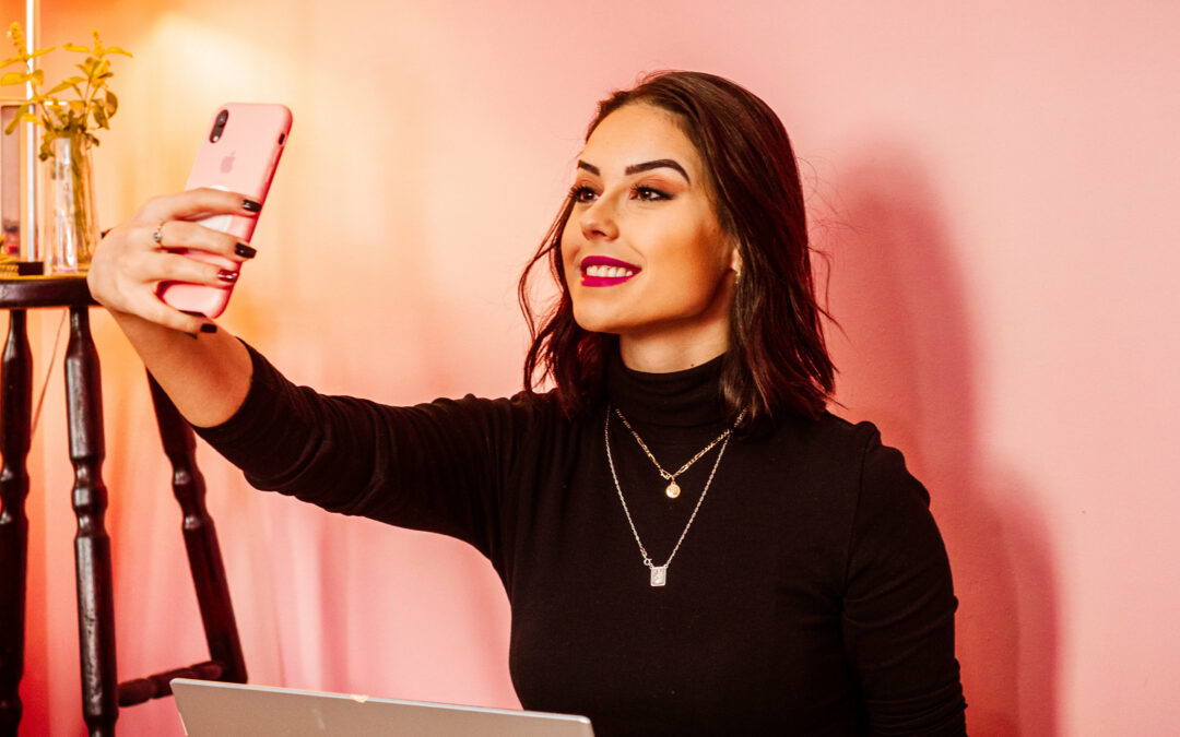 Frau hält ein Smartphone und macht ein Selfie