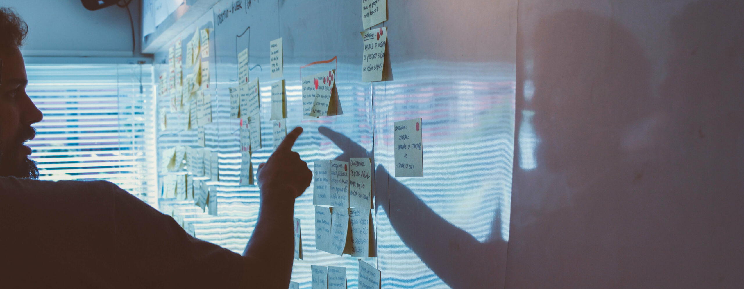Corporate Social Responsibility – Was ist das und was brauche ich zur Umsetzung? Mann steht an Whiteboard mit Post-its
