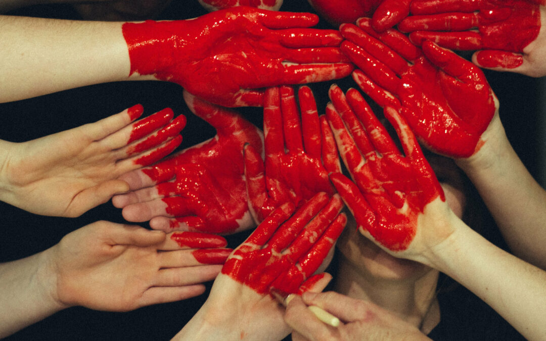 Viele Handflächen mit roter Farbe bedeckt