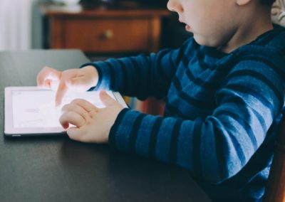 Kind sitzt vor Tablet