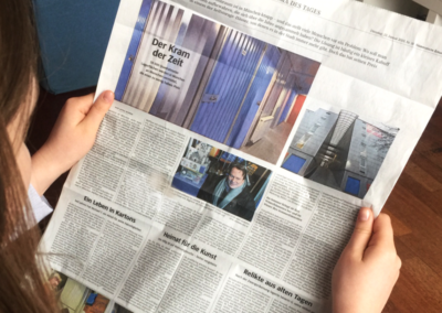 Frau hält Zeitung, aufgeschlagen ist ein Artikel über MyPlace-SelfStorage