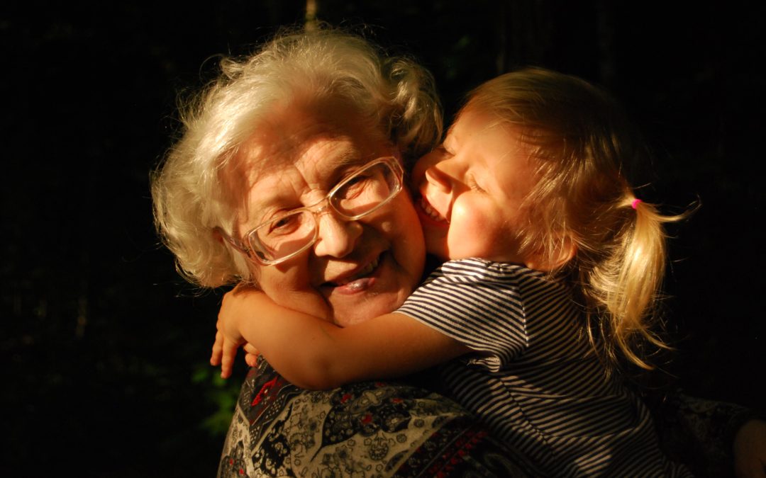 Großmutter mit Mädchen, das sie umarmt