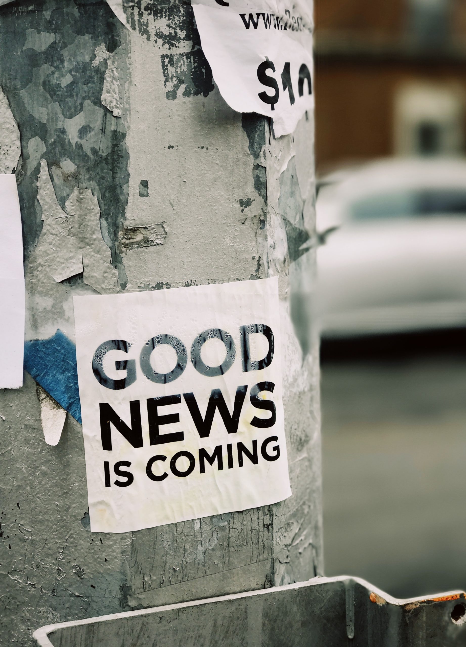 Aufkleber auf Laternenmast: Good News is coming