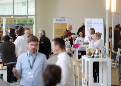 Blick auf die Messestände im Startup-Bereich: Menschen erklären Messebesucher:innen ihre Produkte
