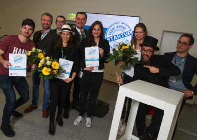 Die Gewinner:innen der Pitches beim Startup-Day der IGW stehen mit Teilen der Jury beieinander und lächeln in die Kamera