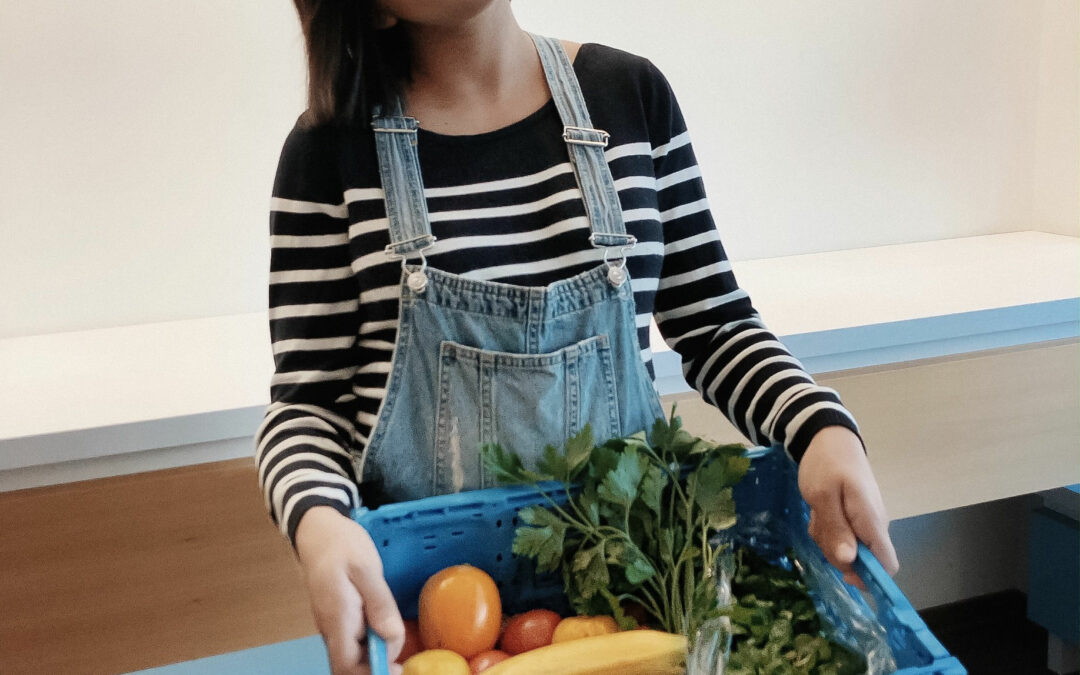 Mädchen trägt Obst und Gemüse im Korb