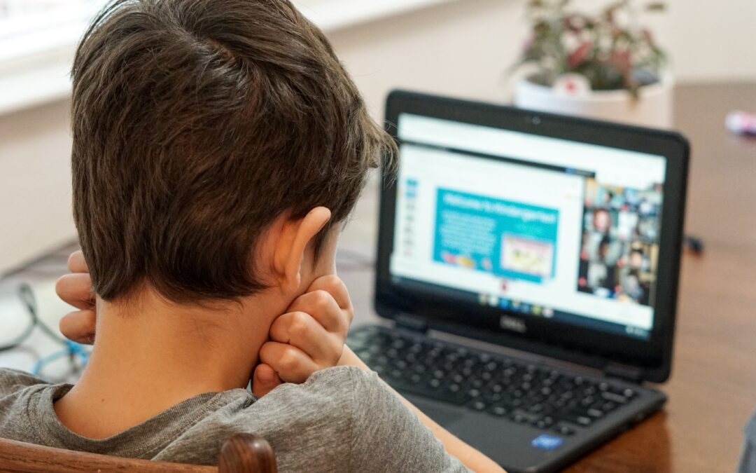 Kind sitzt vor einem Laptop und lernt