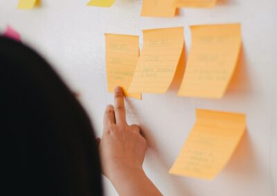 Frau steht vor einem Whiteboard mit bunten Post-its