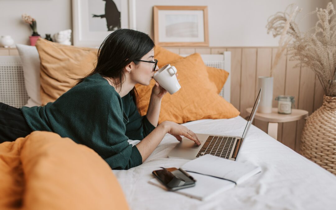 Eine Frau am Laptop auf einem Bett