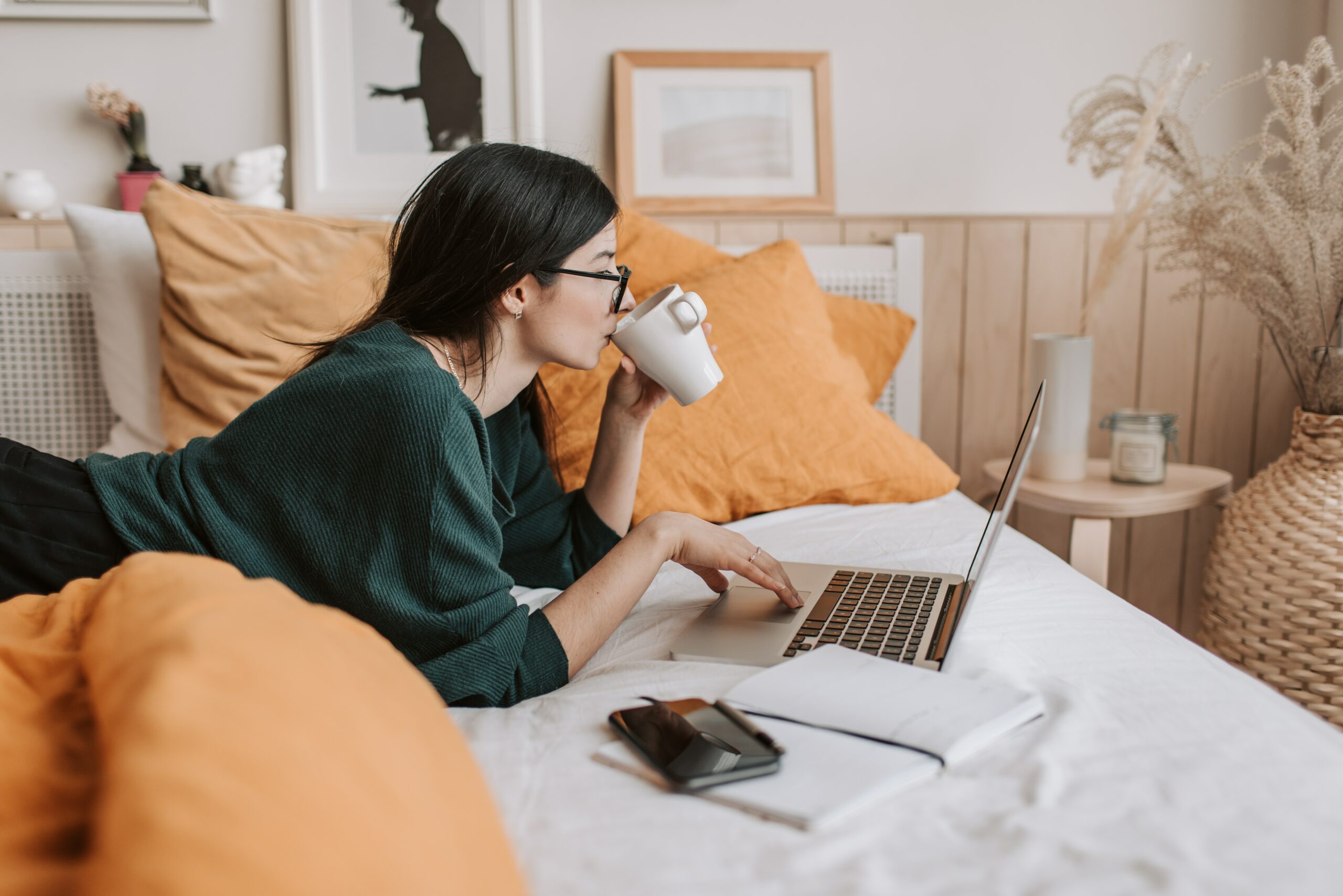 Eine Frau am Laptop auf einem Bett